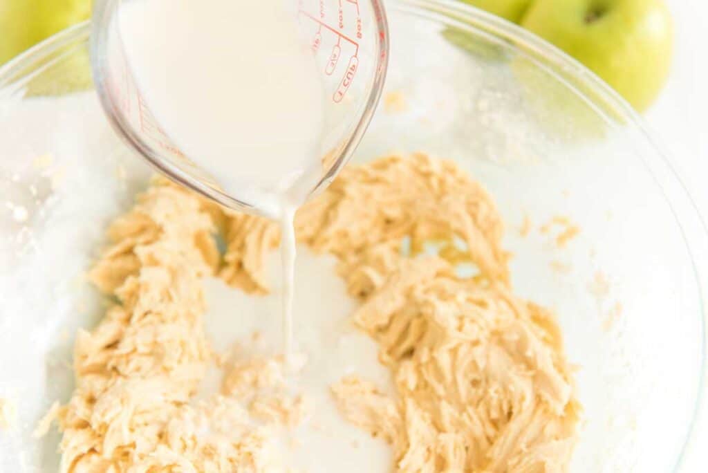 pouring milk into muffin batter