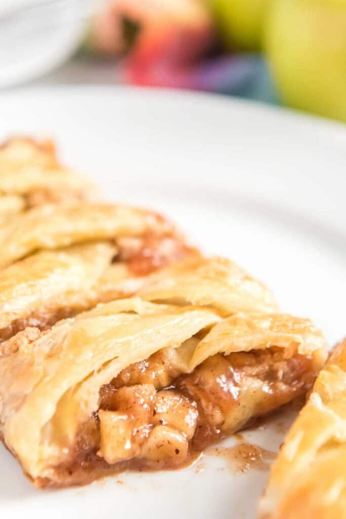 sliced braided apple danish on white plate