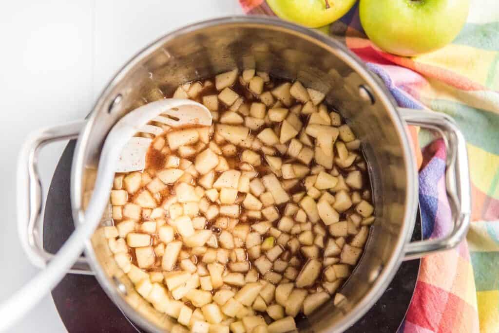 spoon with apple caramel filling in pot