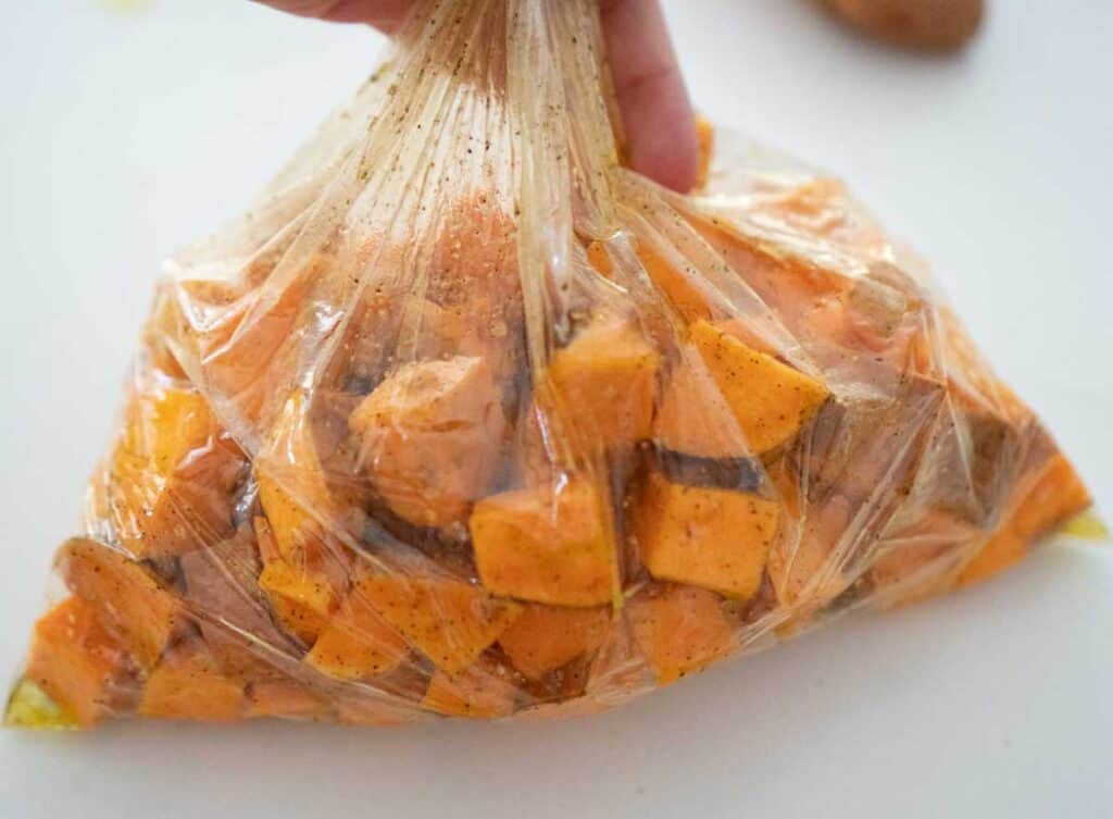sweet potatoes in clear plastic bag coated with olive oil