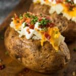 baked potato with sour cream, bacon, cheese, and chives