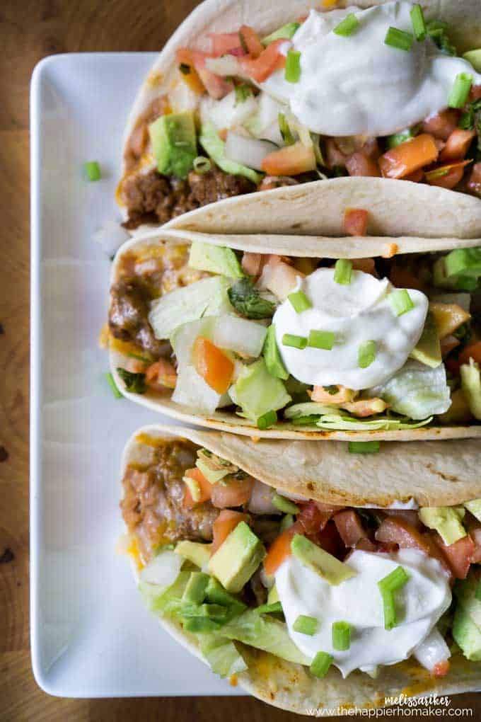 Three oven baked soft tacos on a small white platter 