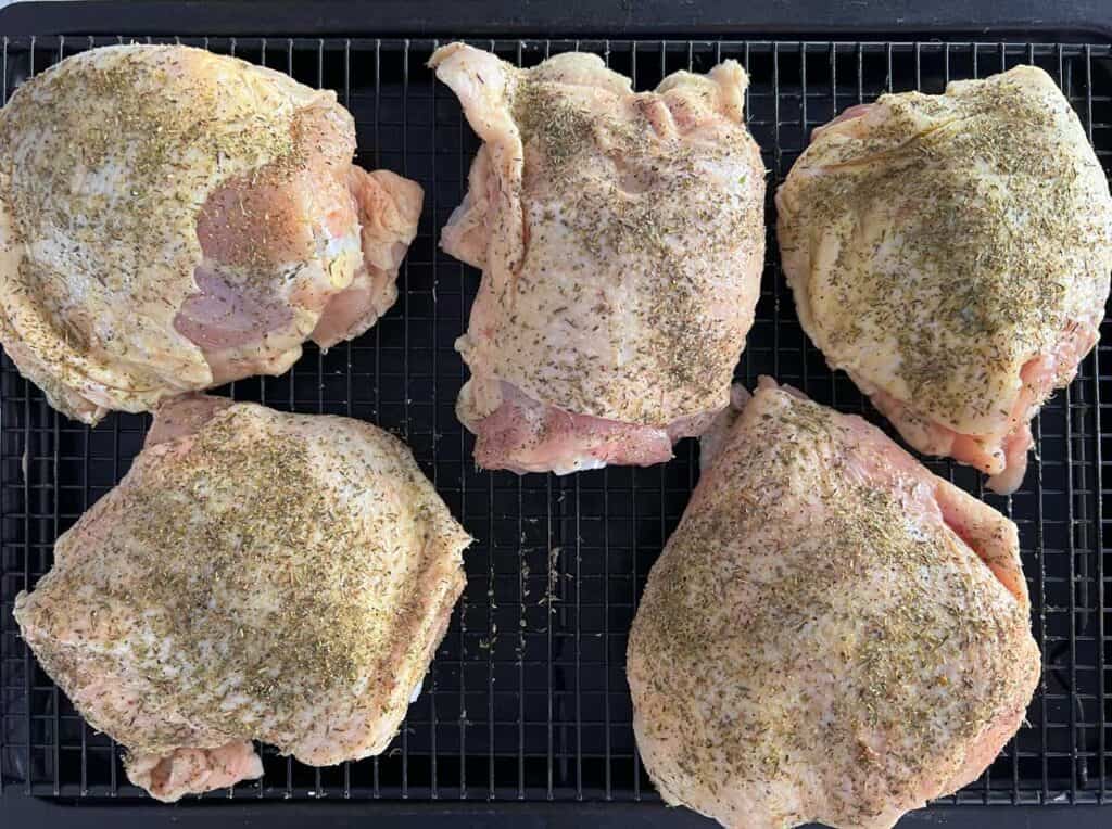 raw chicken thighs on wire rack