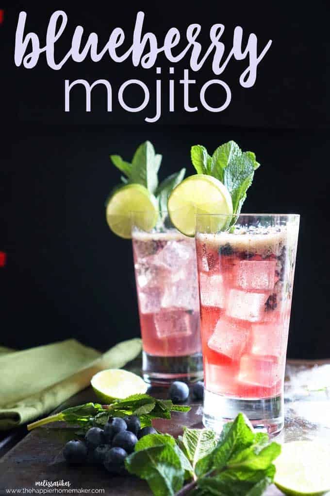 Two blueberry mojitos garnished with lime and mint