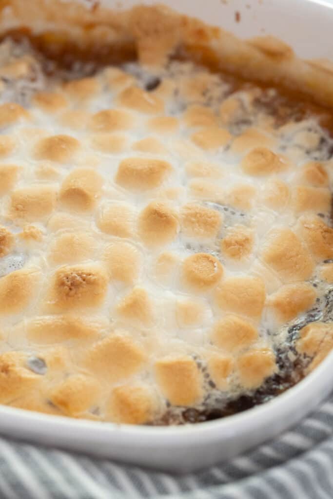 white baking dish with candied yams topped with toasted marshmallows