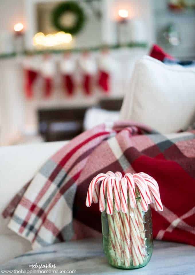 A close up of candy canes in front of a Christmas decorated living room