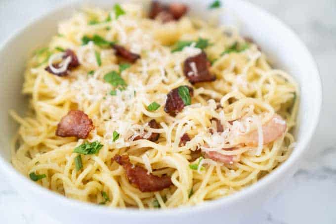 pasta carbonara with bacon in white bowl