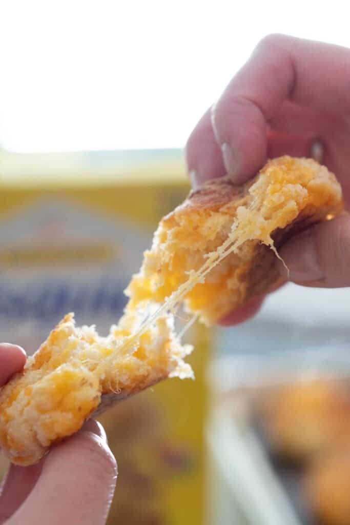 hands pulling apart cheddar biscuit