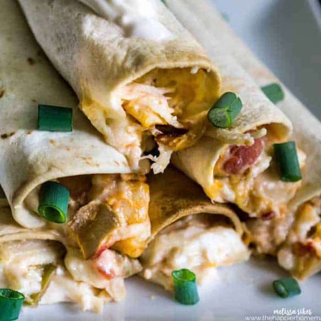 cheesy chicken taquitos stacks on white plate