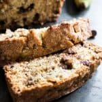 A close up of two slices of chocolate chip banana bread on a table