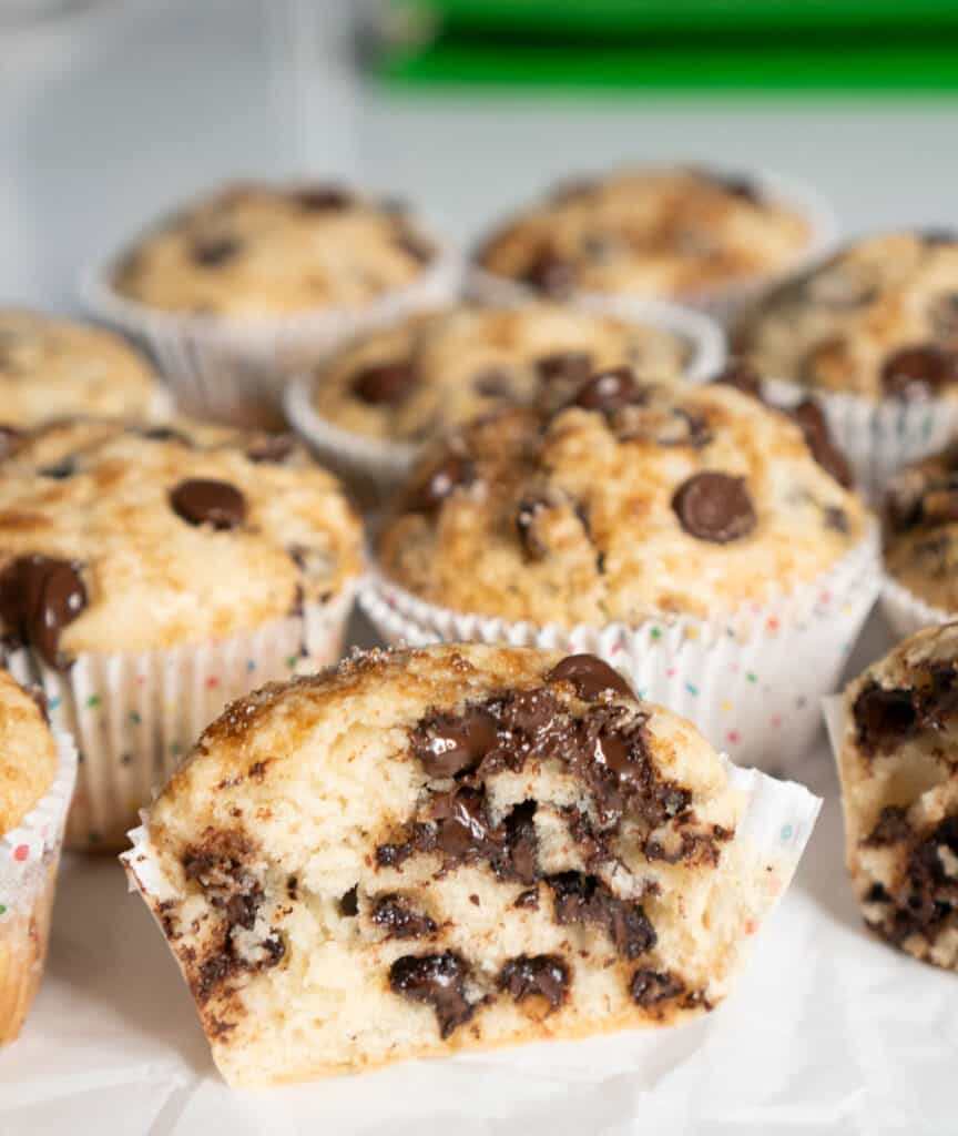 half of a chocolate chip muffin in front of other muffins