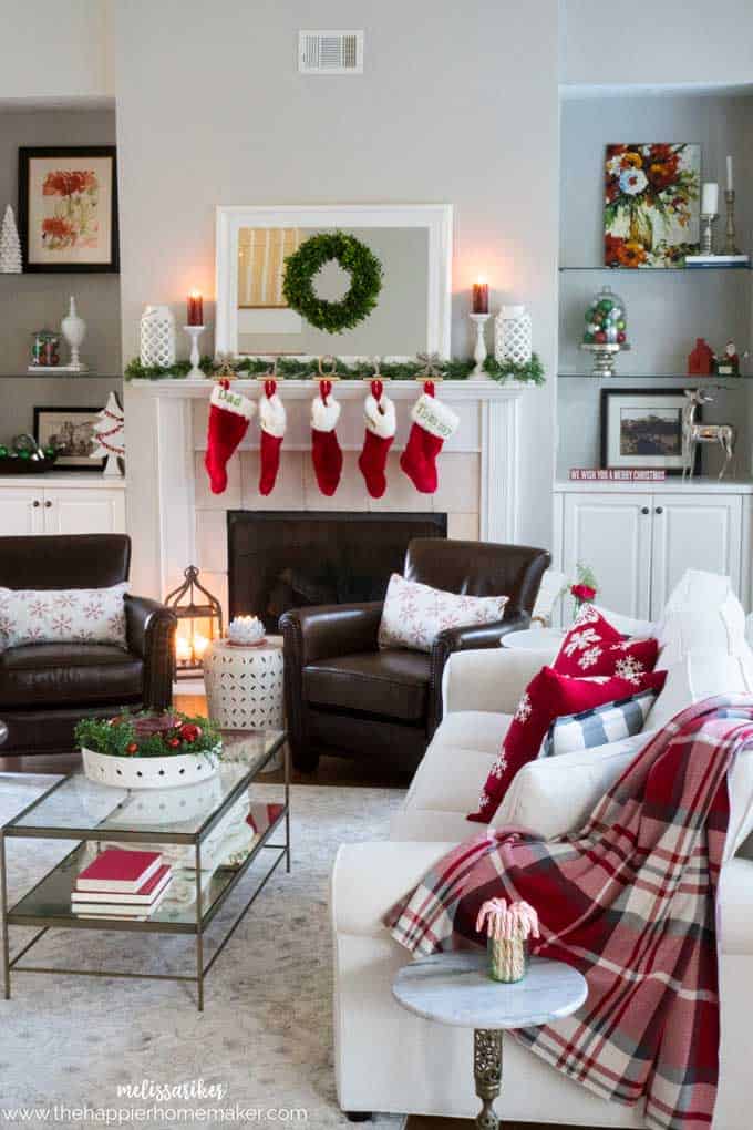 A living room decorated for Christmas with stockings hung on the mantle