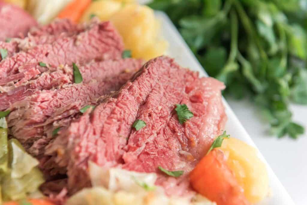 corned beef with cabbage and carrots and potatoes on white platter