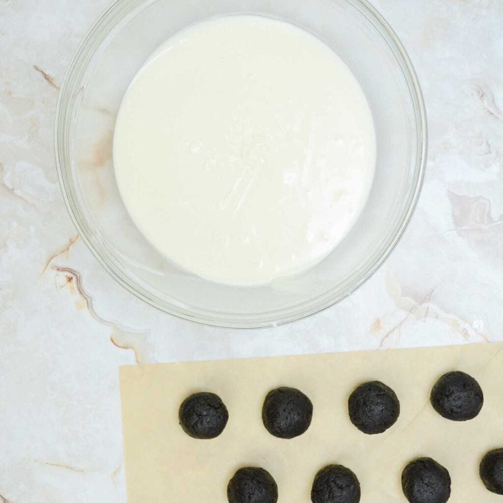 truffle dough balls and glass bowl of melted white chocolate