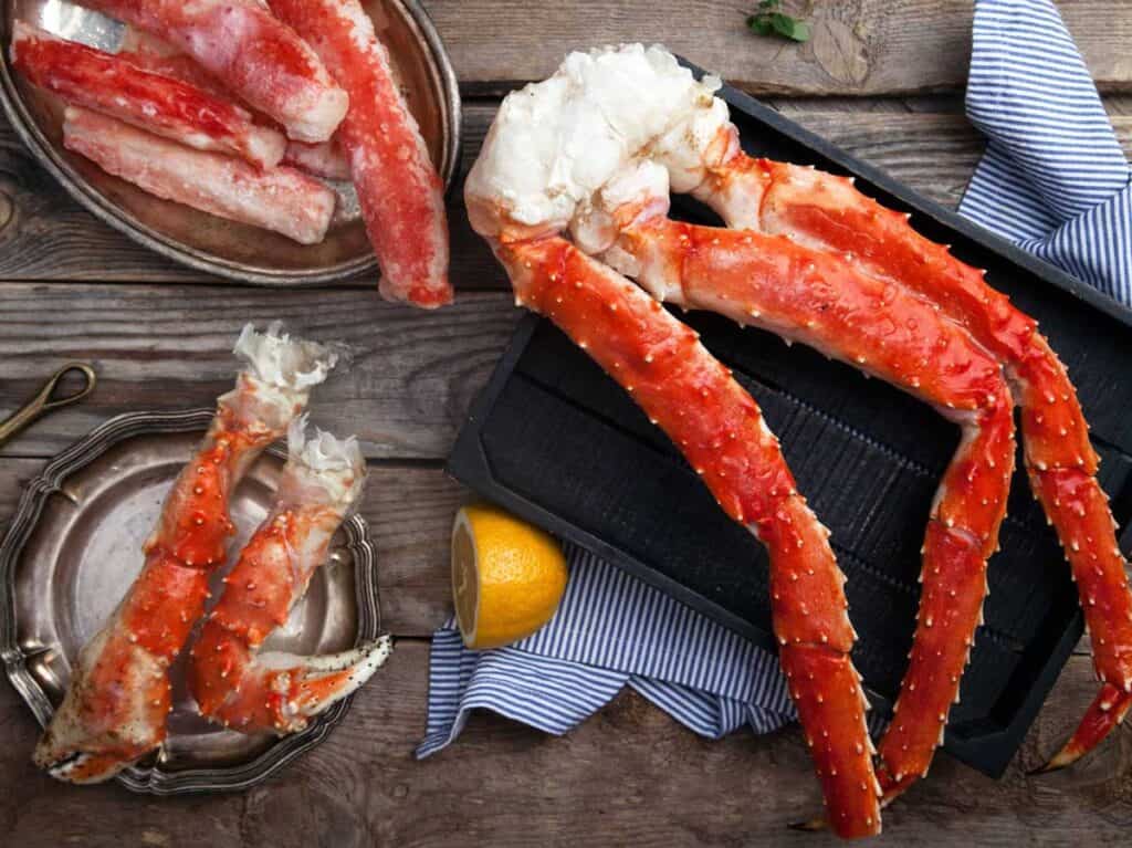 crab legs on wooden table with half a lemon
