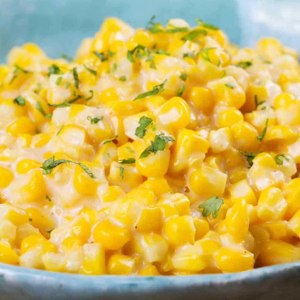 close up of creamed corn in blue bowl