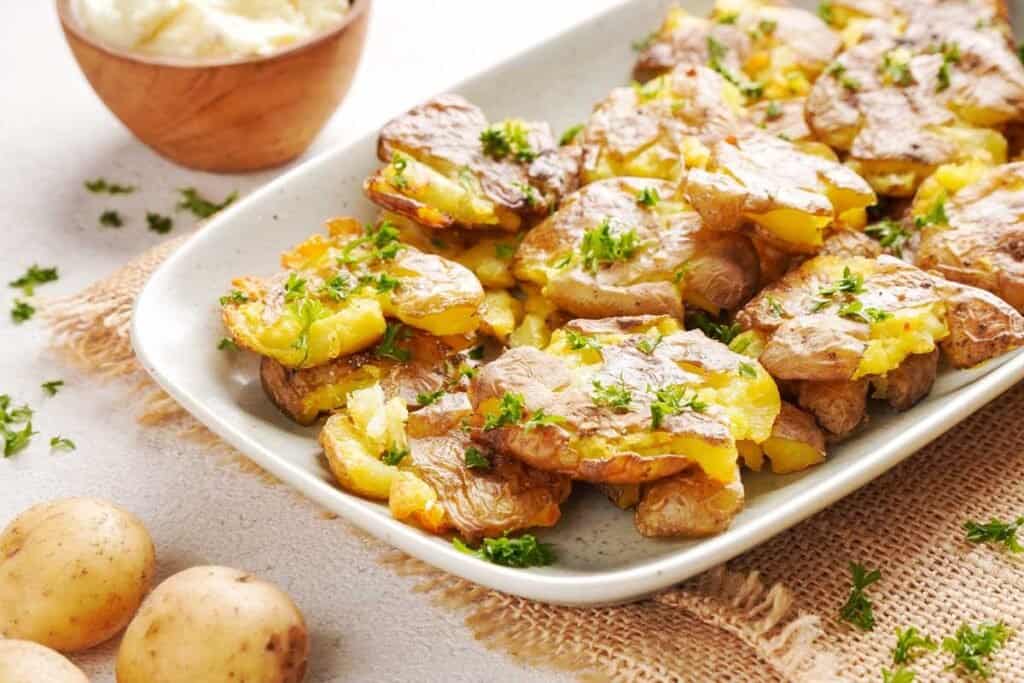 crispy smashed potatoes on white platter