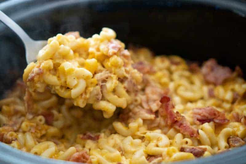 spoon scooping crock pot bacon mac and cheese