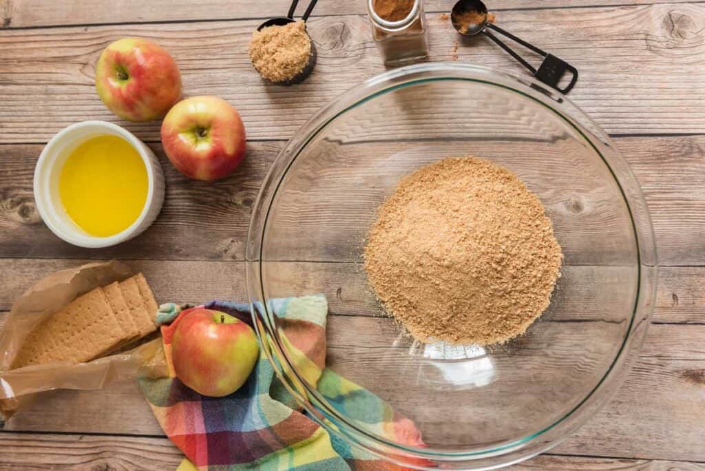 graham cracker crust ingredients in glass bowl and measuring spoons