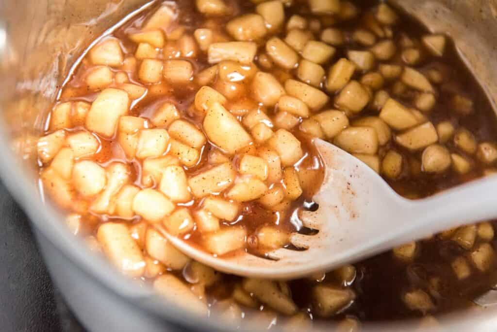 spoon with apple caramel filling in pot