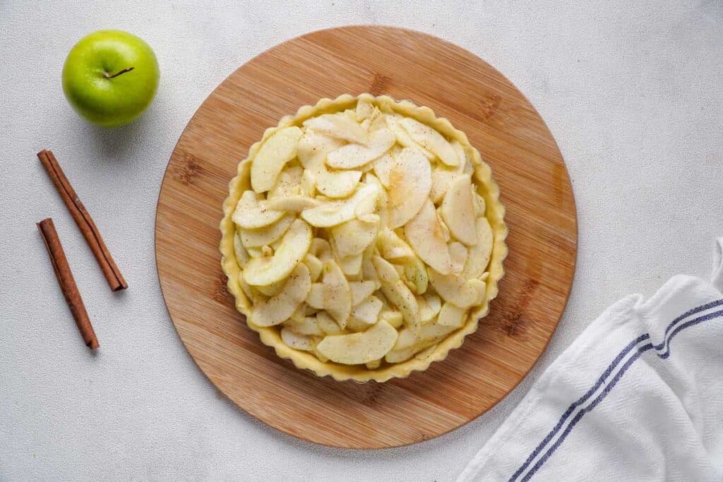 pie crust with apple pie filling before baking