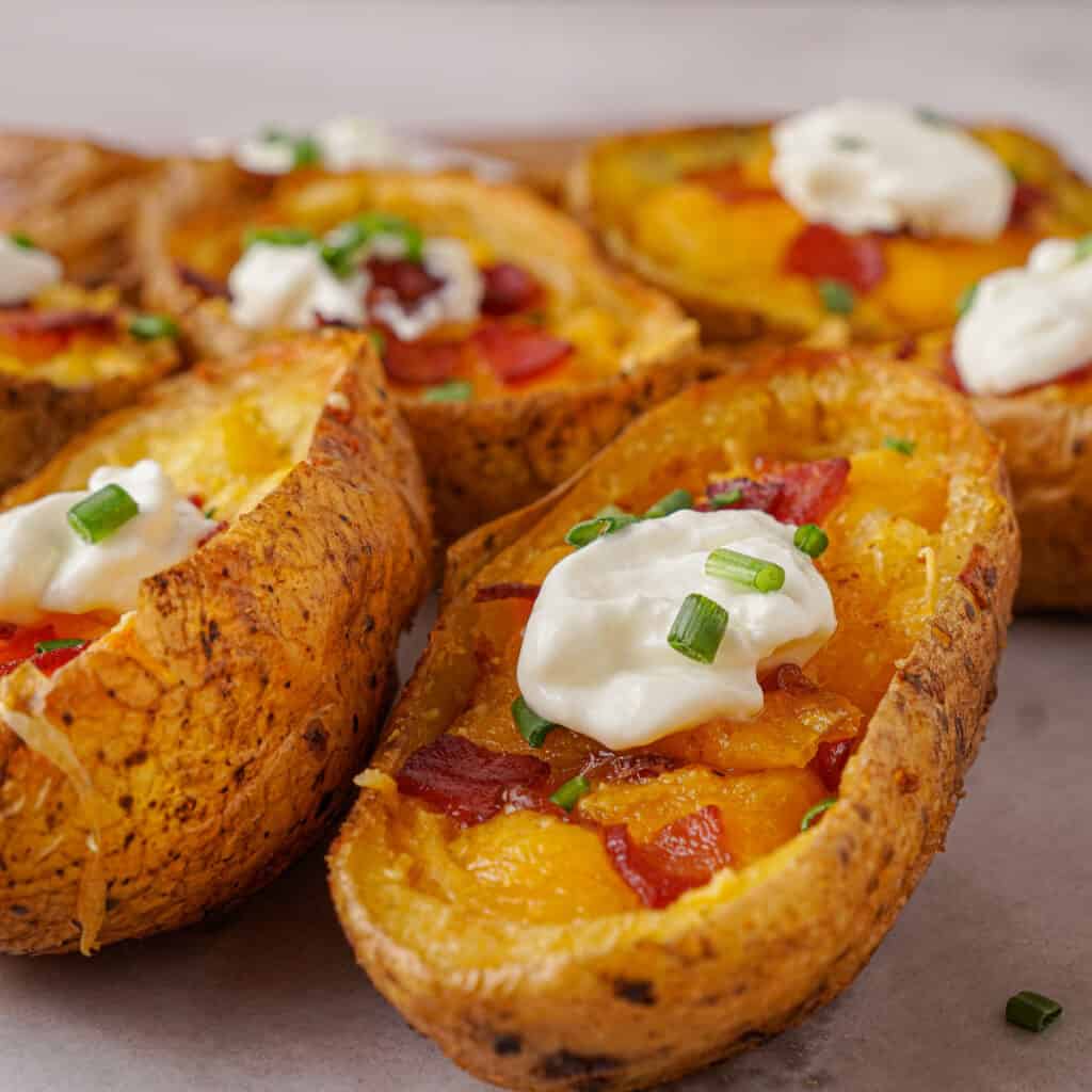 close up of crispy potato skins with sour cream and chives