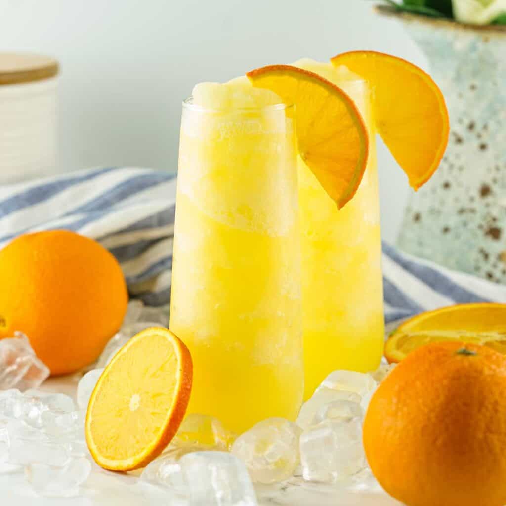 two frozen mimosas with orange slices