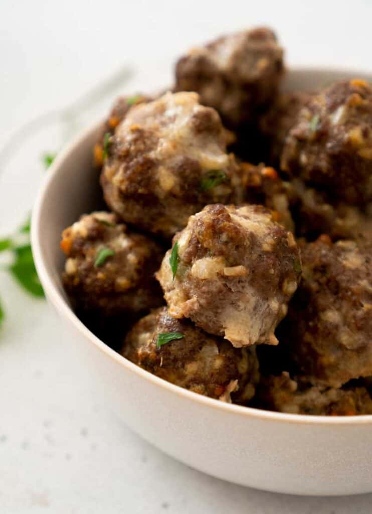 homemade meatballs in white ceramic bowl on white counter