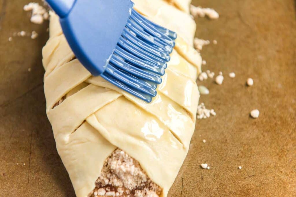 brushing egg wash onto braided danish