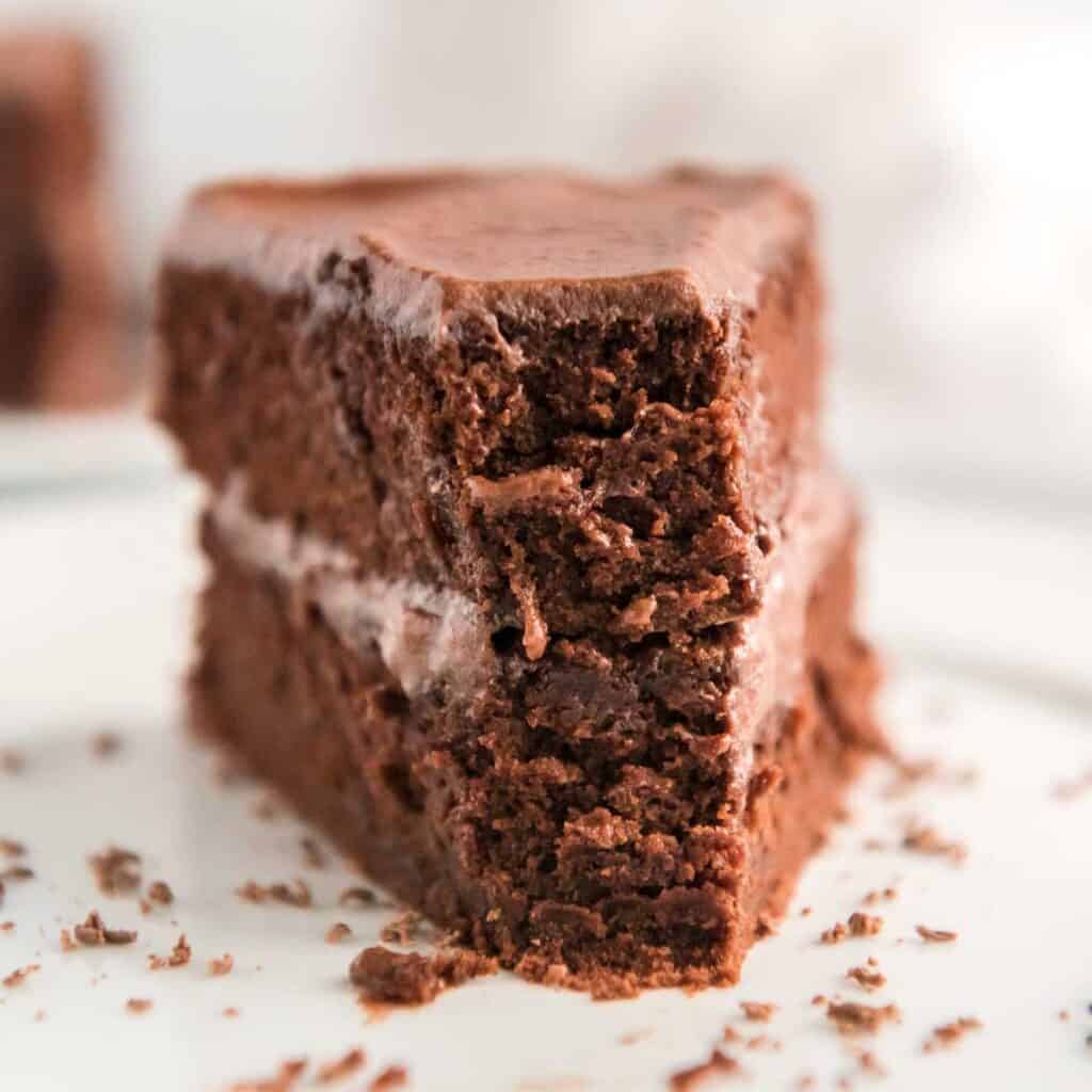 slice of chocolate cake on white plate with bite missing