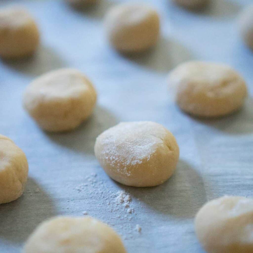 balls of cookie dough on parchment paper