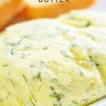 garlic butter on white plate with bread in the background