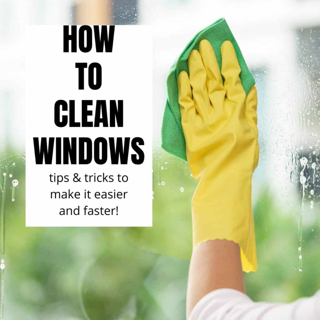hand in yellow glove cleaning a window with a green cloth