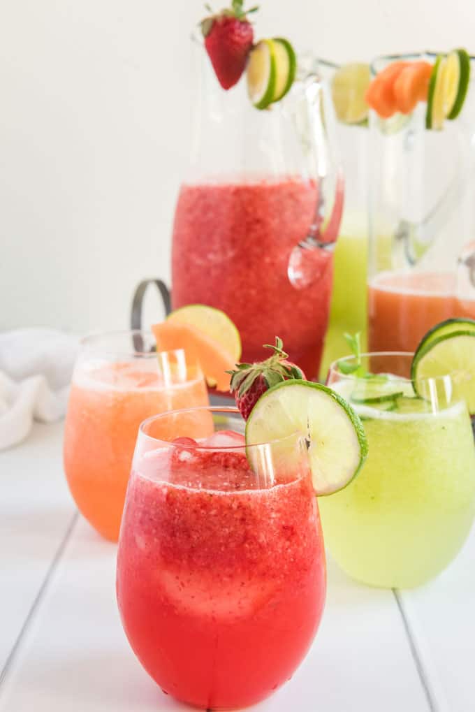 strawberry, cantaloupe and cucumber agua fresca in glasses with pitchers