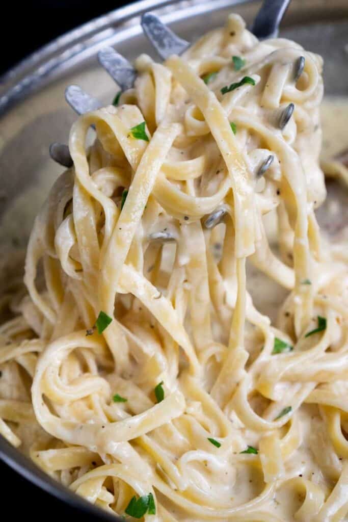 scopping fettuccine alfredo out of large skillet
