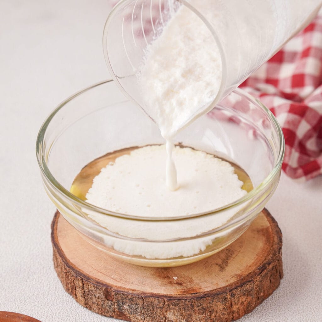 pouring buttermilk egg mixture into cornmeal and flour in bowl