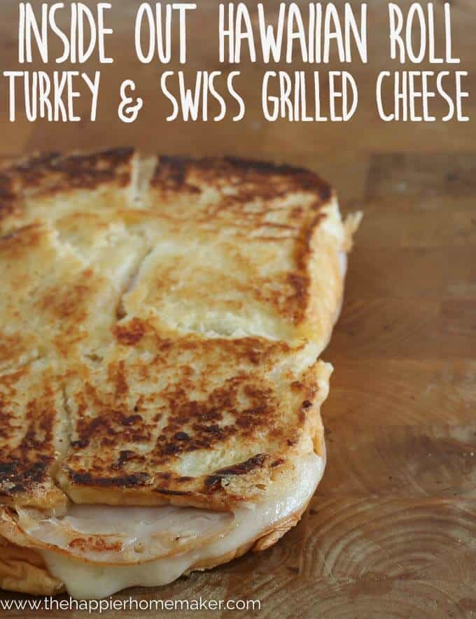 A close up of an inside out grilled Turkey Swiss sandwich on a wooden cutting board