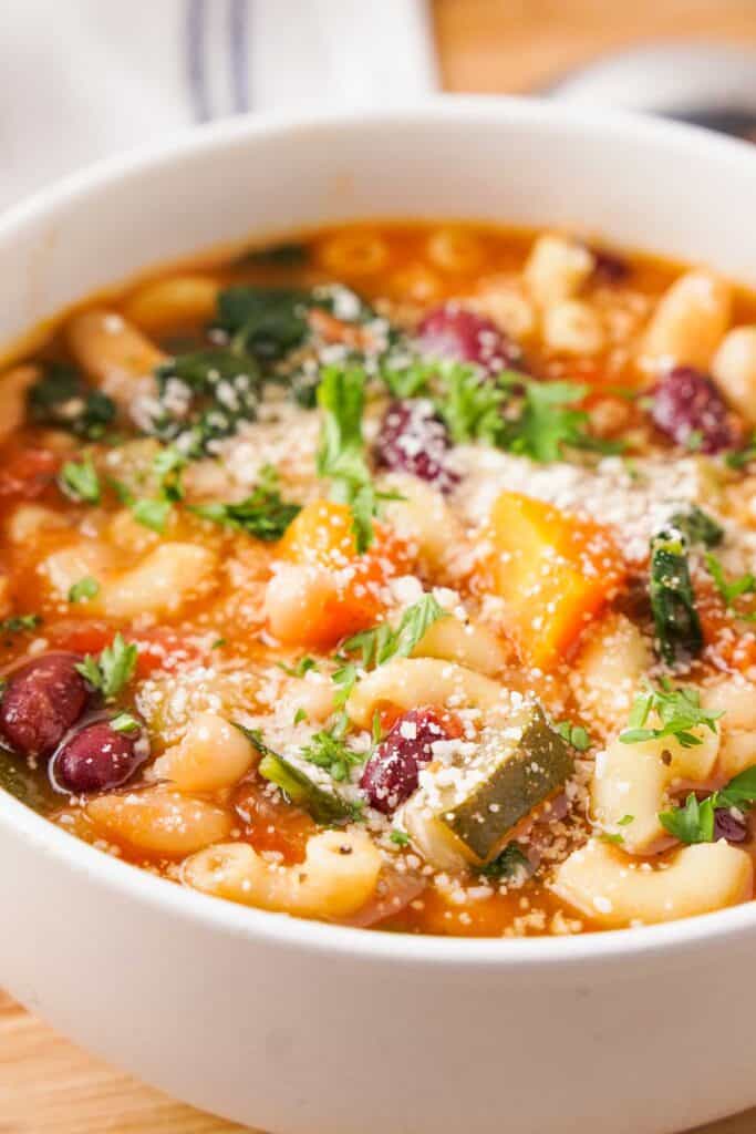 close up of white bowl with minestrone soup