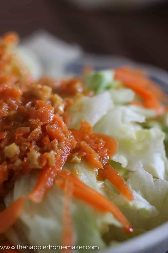 extreme close up of Japanese Ginger Salad Dressing over iceberg lettuce and shredded carrot