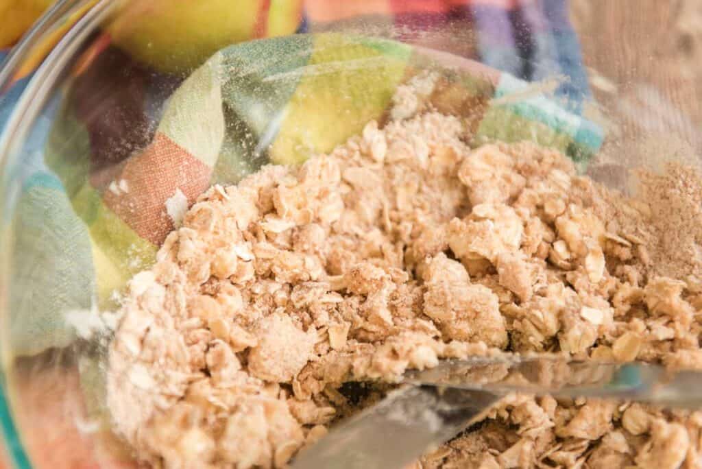 two forks cutting together butter and oats and brown sugar for crisp topping