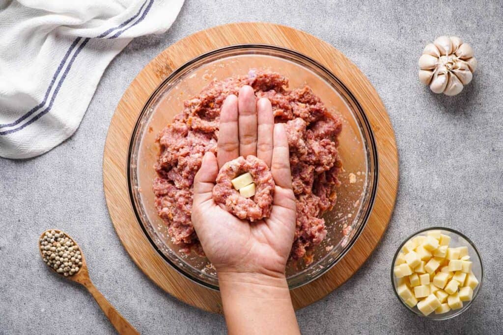 hand holding cheese stuffed meatball half