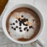 A cup of hot chocolate with Nutella on a white table cloth