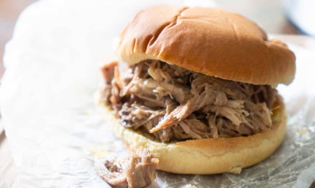 pulled pork sandwich on crumpled wax paper