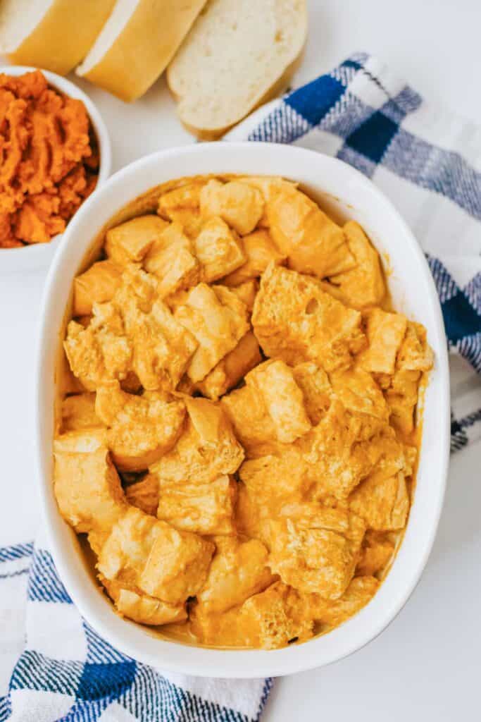 pumpkin bread pudding in white dish before baking