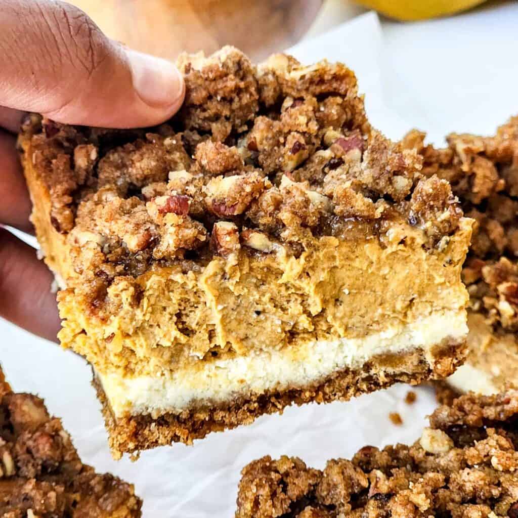 hand holding pumpkin cheesecake bar