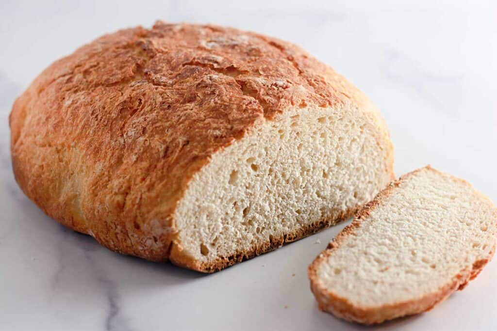 Dutch oven bread loaf with one slice cut