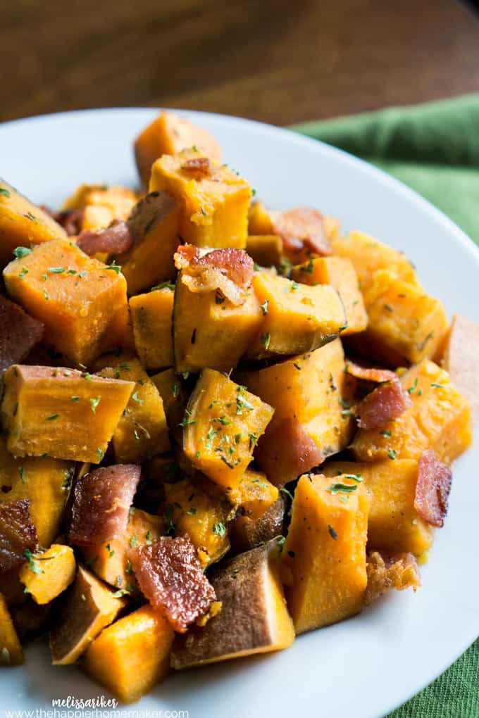 cooked diced sweet potatoes with bacon and parsley on white plate