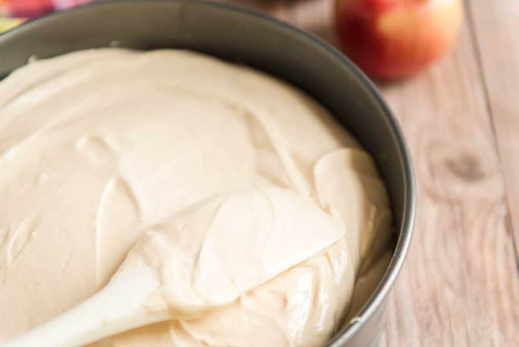 spatula smoothing cheesecake filling in pan