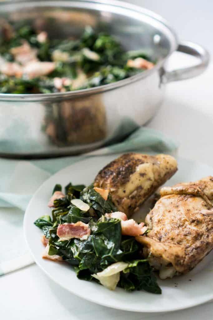 southern collard greens on white plate with chicken