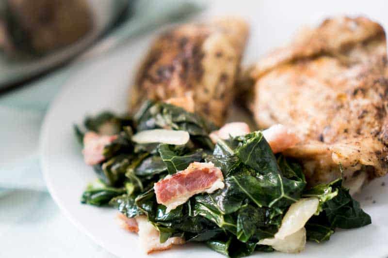 southern collard greens on white plate with chicken